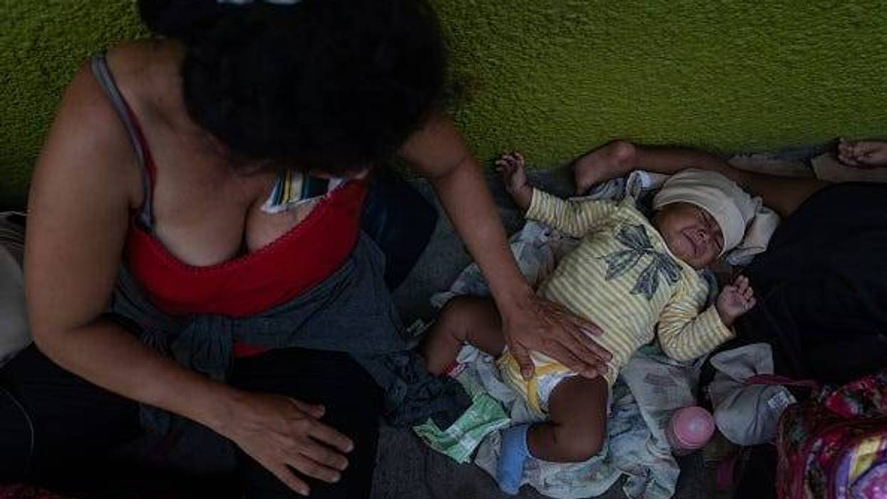 A Honduran migrant and her baby take shelter on a sidewalk on June 19, 2019 in Tapachula, Mexico. Since shelters in the city are over capacity, many migrants are living on sidewalks while they wait for their appointments to obtain a humanitarian visa.