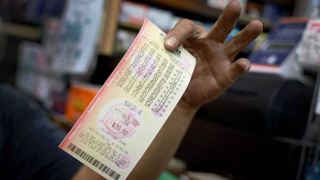 A hopeful lottery ticket holder shows off his Mega Millions lottery ticket that he bought at Bob's News & Books store on August 04, 2023 in Fort Lauderdale, Florida.