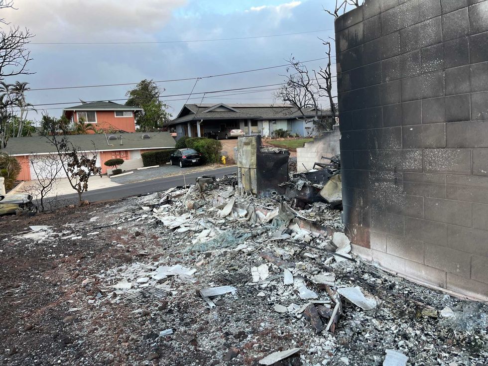 A house sits in rubble as its neighboring residences remain mostly untouched.