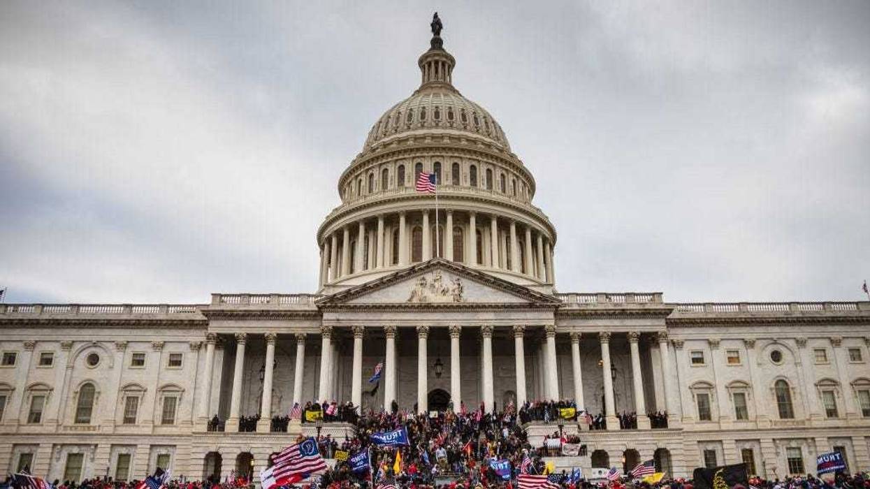 A large group of pro-Trump protesters stand on the East steps of the Capitol Building after storming its grounds on January 6, 2021 in Washington, DC. A pro-Trump mob stormed the Capitol, breaking windows and clashing with police officers.