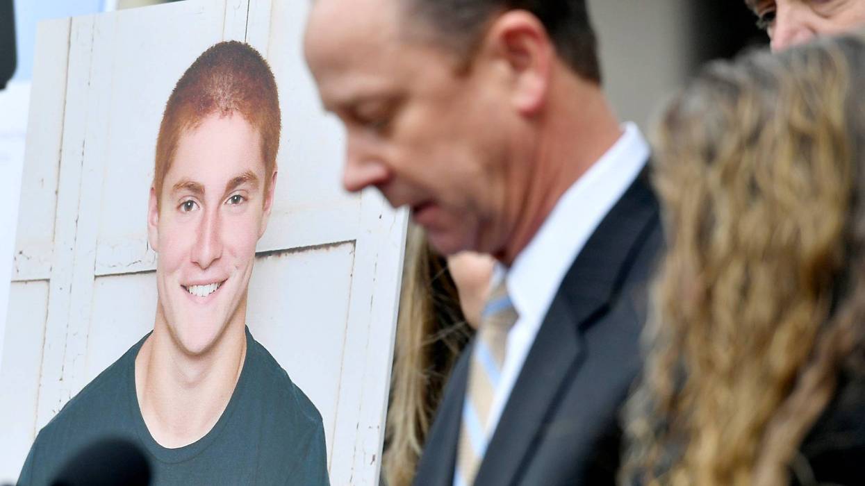 A large photo of Timothy Piazza next to his father Jim Piazza as he speaks about the importance of passing the anti-hazing legislation named after his son outside of the Centre County Courthouse on March 23, 2018, in Bellefonte, Pennsylvania.
