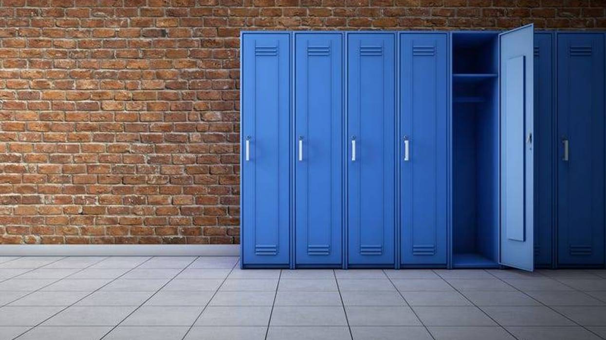 A line of lockers against a brick wall in a school hallway