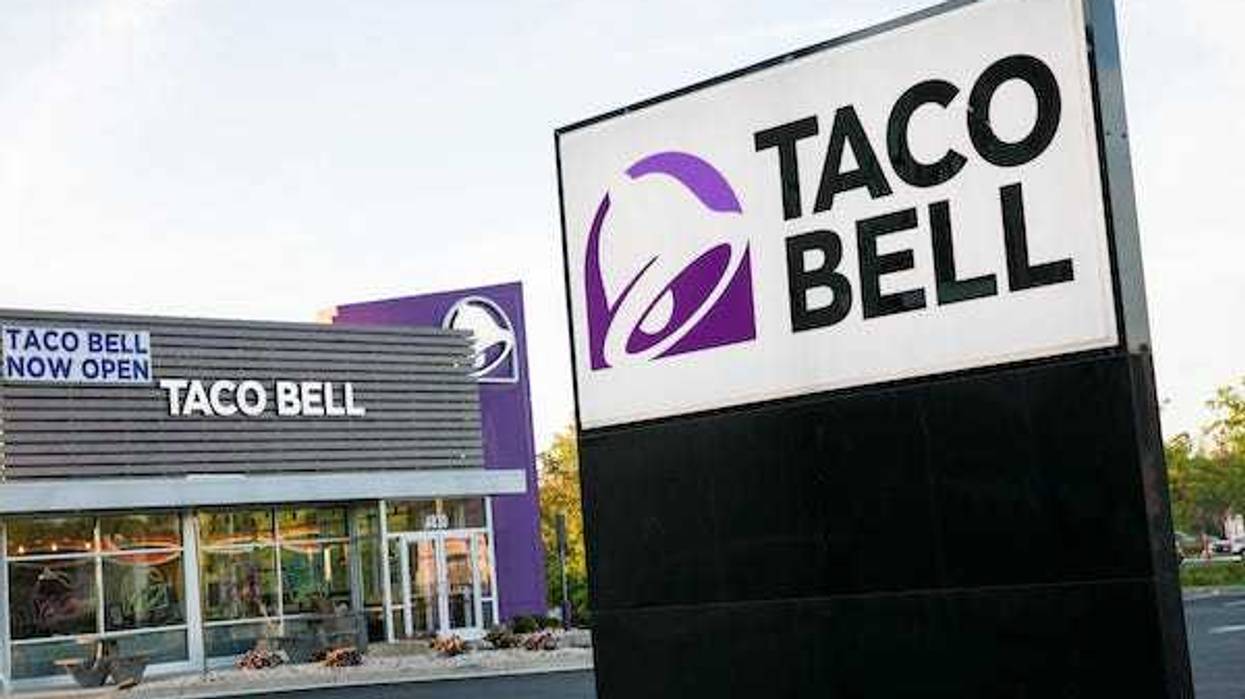 A logo sign outside of a Taco Bell restaurant location in Winchester, Virginia