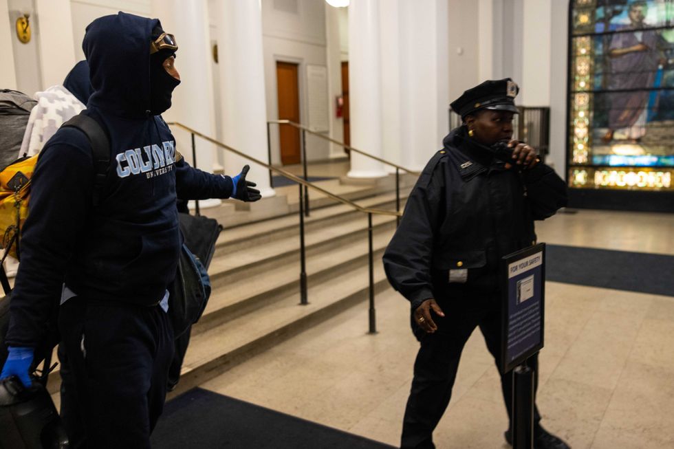 A lone officer reacts as multiple demonstrators enter into Hamilton Hall where they proceeded to barricade themselves in the academic building which has been occupied in past student movements, on Tuesday, April 30, 2024