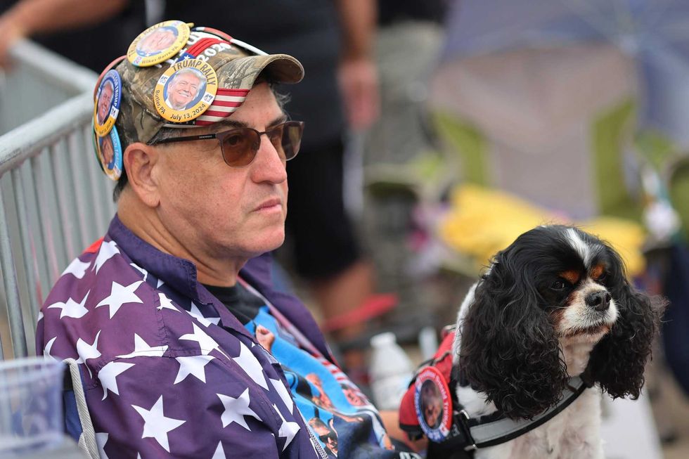 A man and a dog wait outside Nassau Coliseum on Wednesday morning
