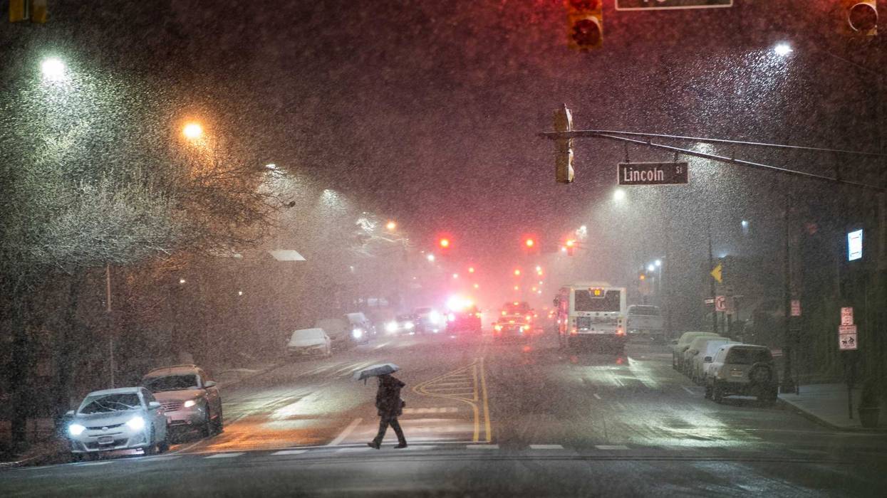 A man covers himself of snow during a winter storm around Times Square on February 27, 2023 in Hoboken, New Jersey