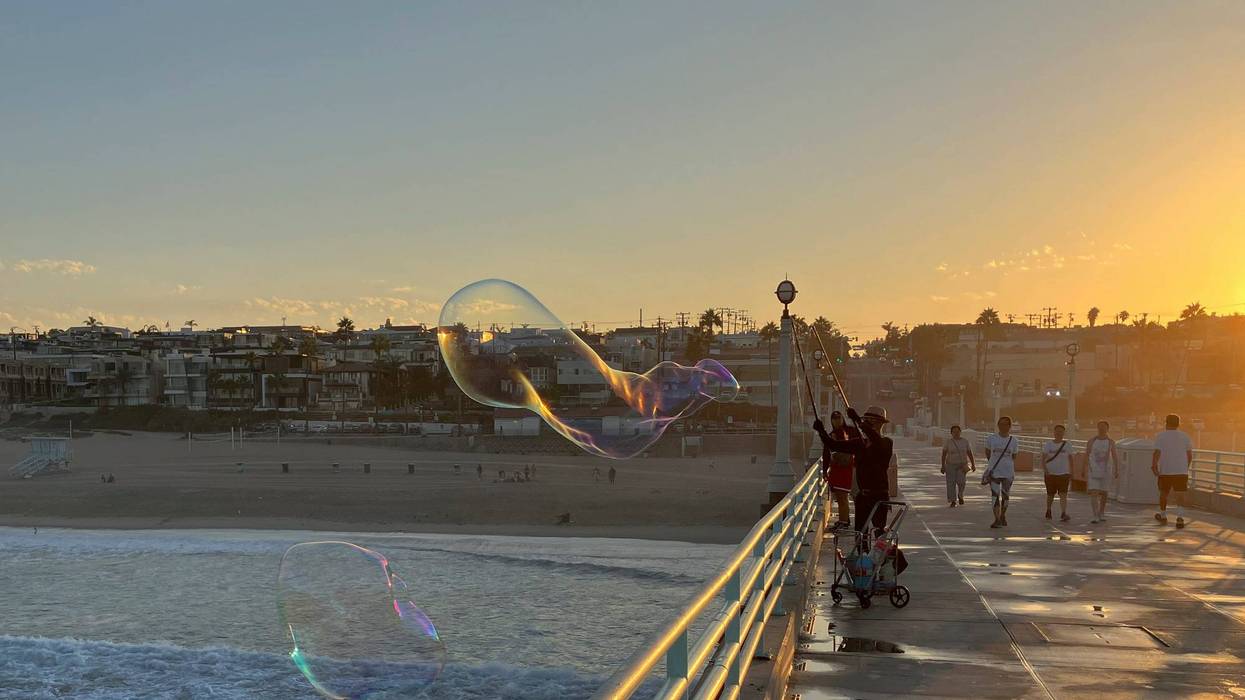 A man creates giant soap suds bubbles at dawn Monday, Sept. 5, on the Manhattan Beach Pier in Manhattan Beach, Calif., as a severe heat wave gripped the state. Most of California's 39 million people are facing sweltering weather.