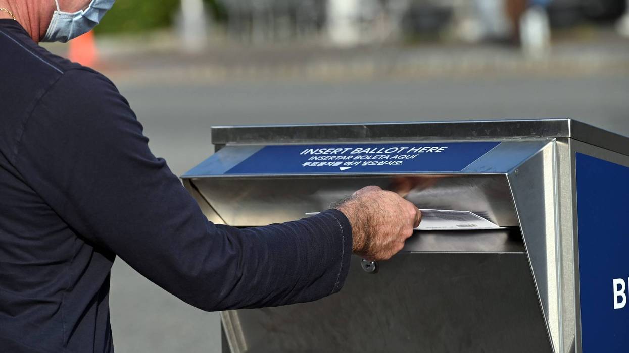 A man deposits his ballot in an election ballot drop box
