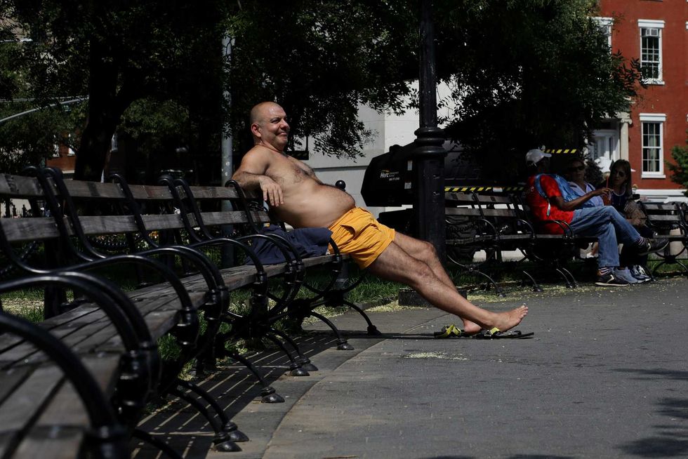 A man enjoys a sunny day at Washington Square Park on July 27, 2023