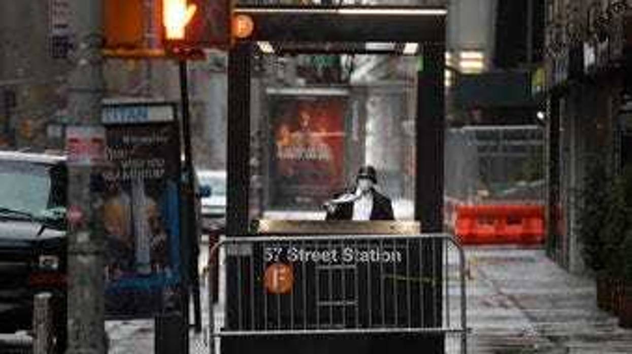 A man enters the subway on a rainy day in New York, Monday, April 13, 2020. Gov. Andrew Cuomo says New York's death toll from coronavirus has topped 10,000, with hospitals still seeing 2,000 new patients a day. (AP Photo/Seth Wenig)