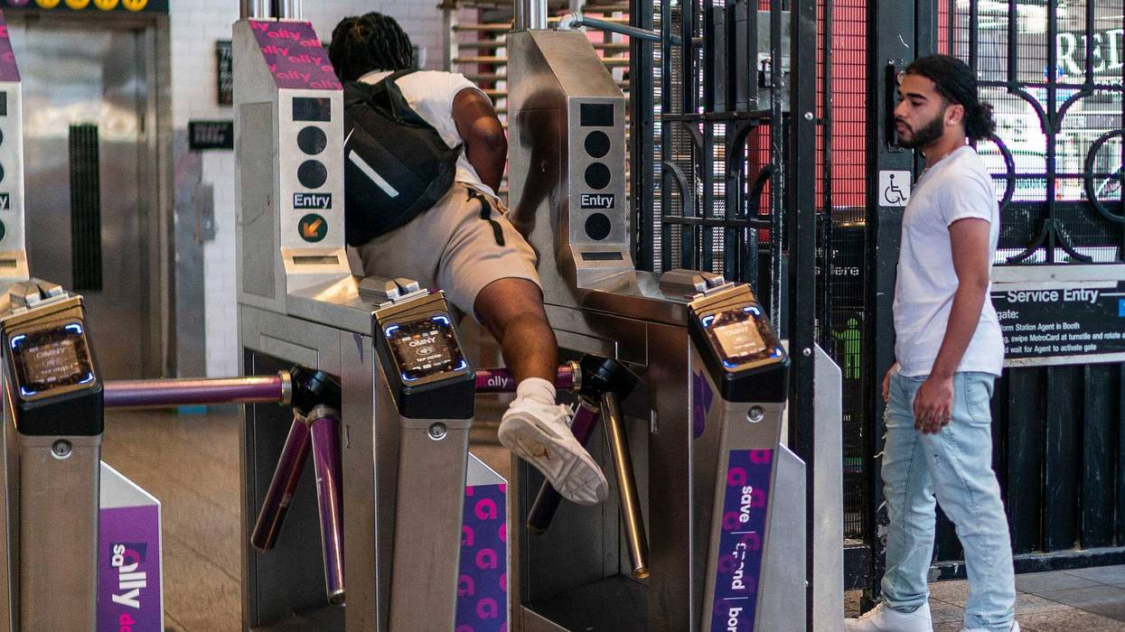 A man goes over a subway turnstile without paying the MTA fare at the Times Square station on June 5, 2023