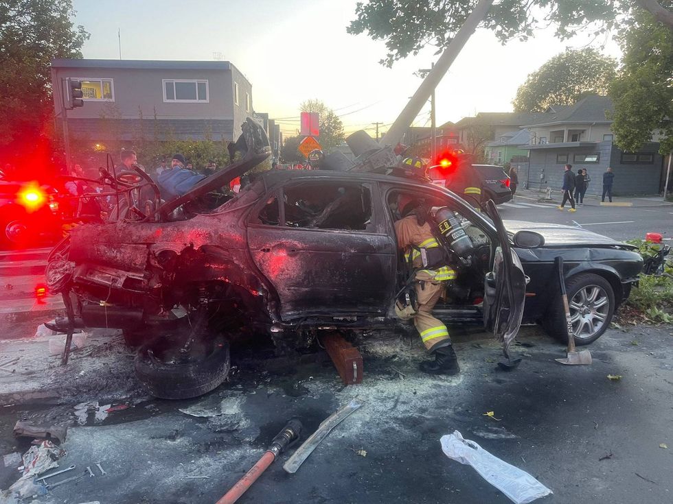 A man has survived a fiery car crash after Oakland residents used hoses and bottles of water to keep him alive until emergency crews arrived.