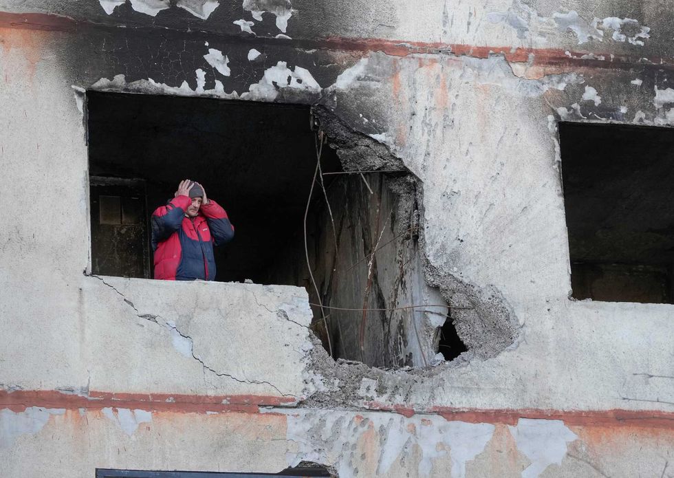 A man holds his head as he stands in his apartment in a multi-story house that was destroyed following a Russian attack in Kharkiv, Ukraine, Thursday, March 24, 2022