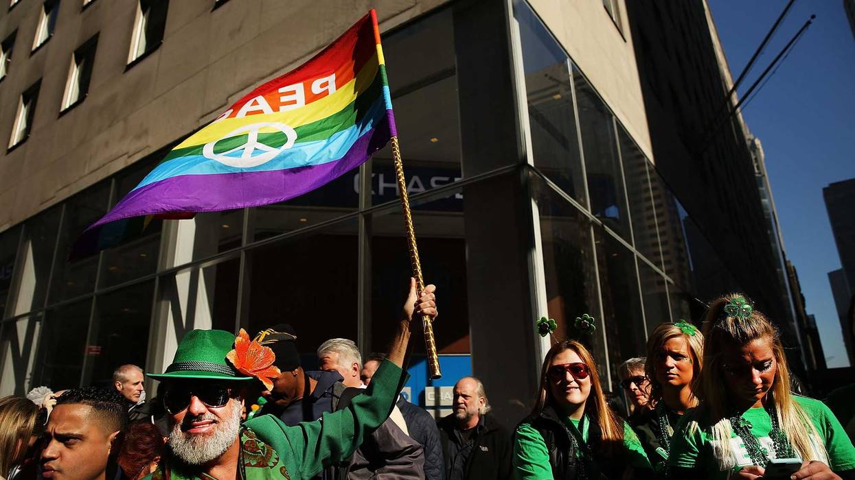 A man holds up a Pride flag at the annual St. Patrick's Day parade in Manhattan, where LGBTQ groups are allowed to march in the parade
