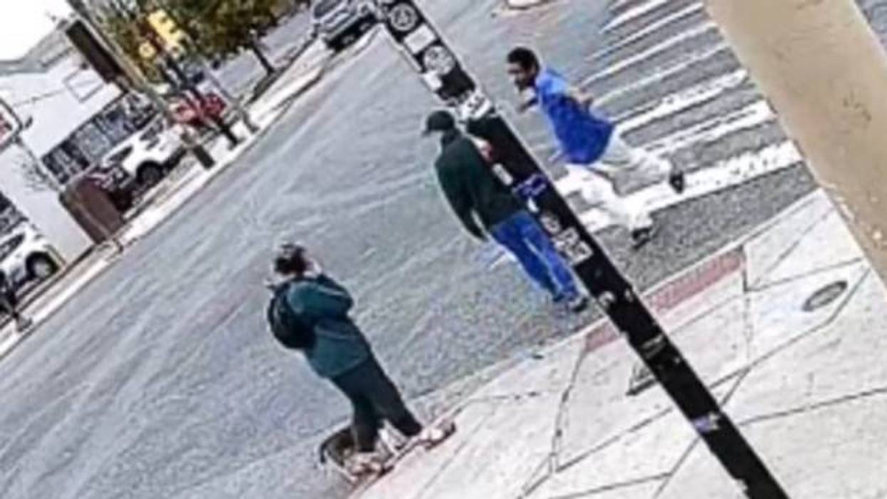 A man in a blue shirt and white pants attacks another man while crossing 10th and Reed streets in South Philadelphia on Sunday, Oct. 4.