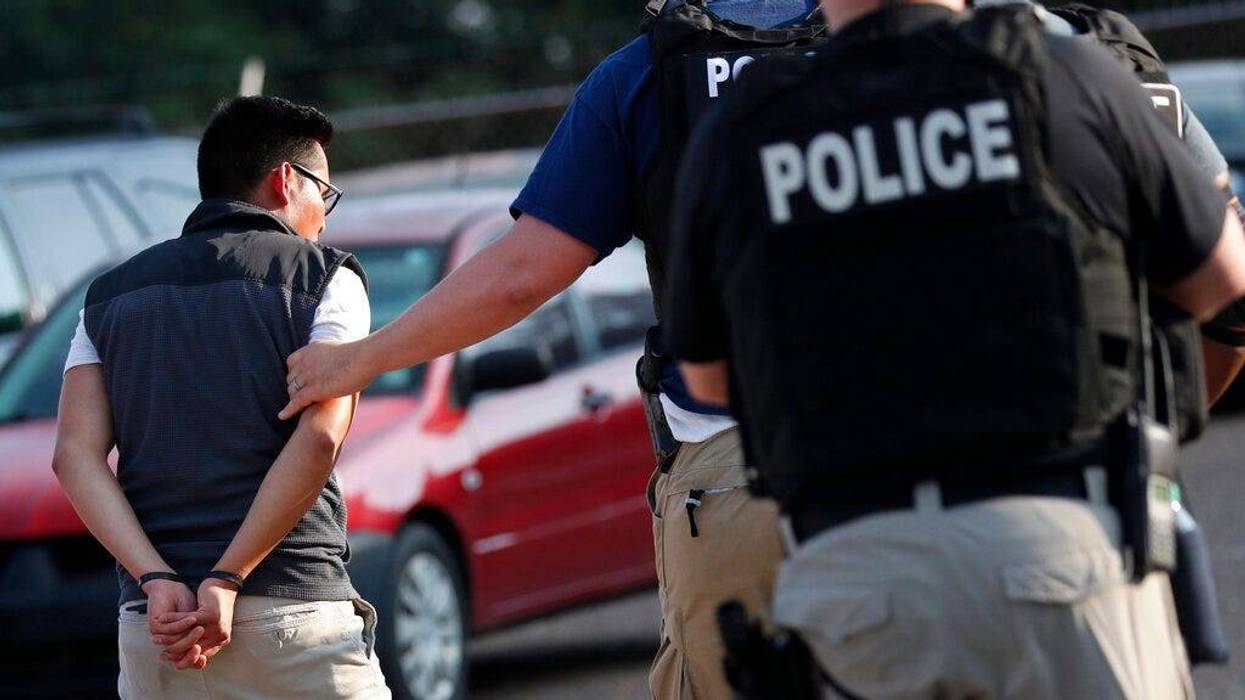 A man is taken into custody at a Koch Foods Inc. plant in Morton, Miss.
