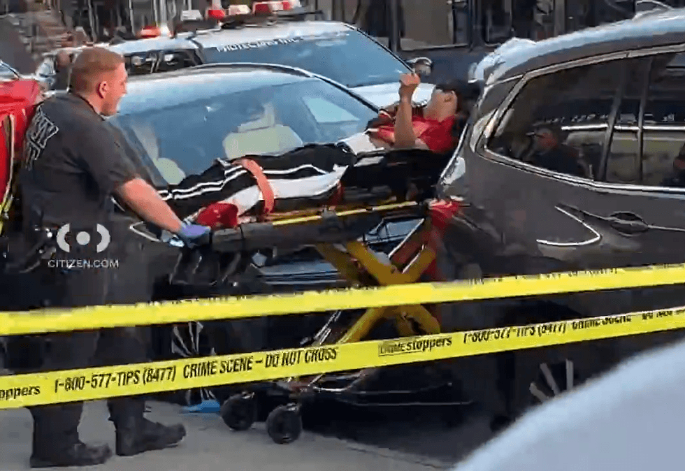 A man is wheeled from the scene on a stretcher