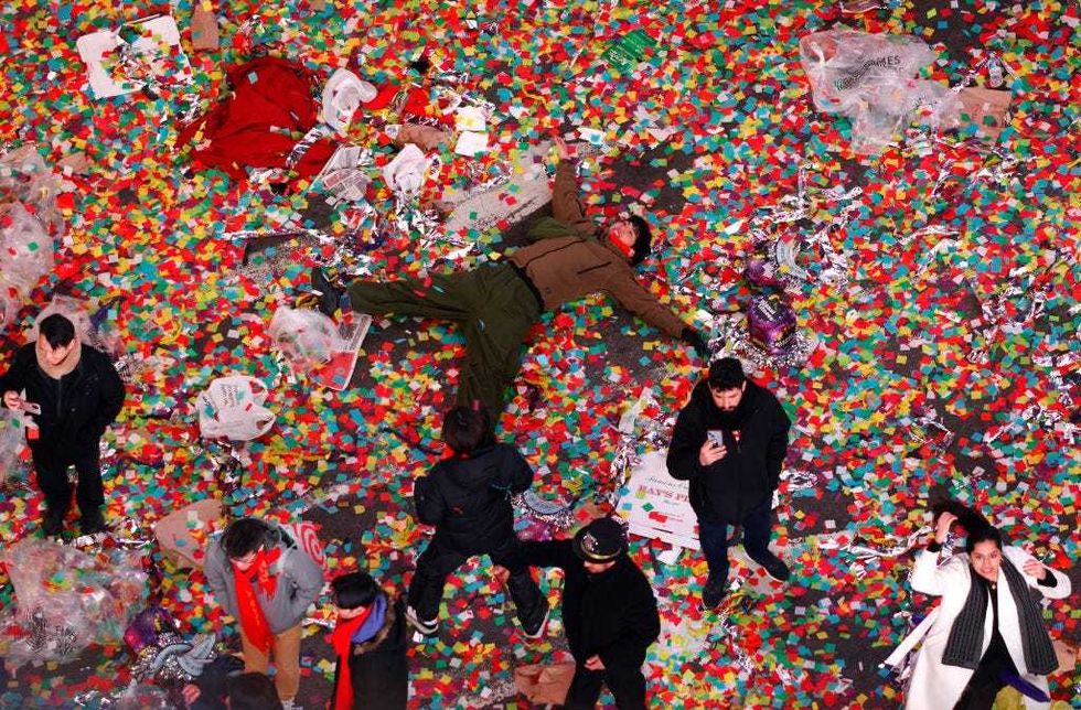 A man lays in confetti following New Year