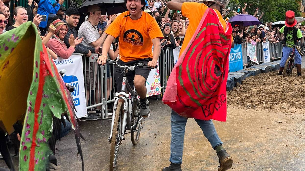 A man on a bike screams as he rides through the mud pit at the Kensington Derby.