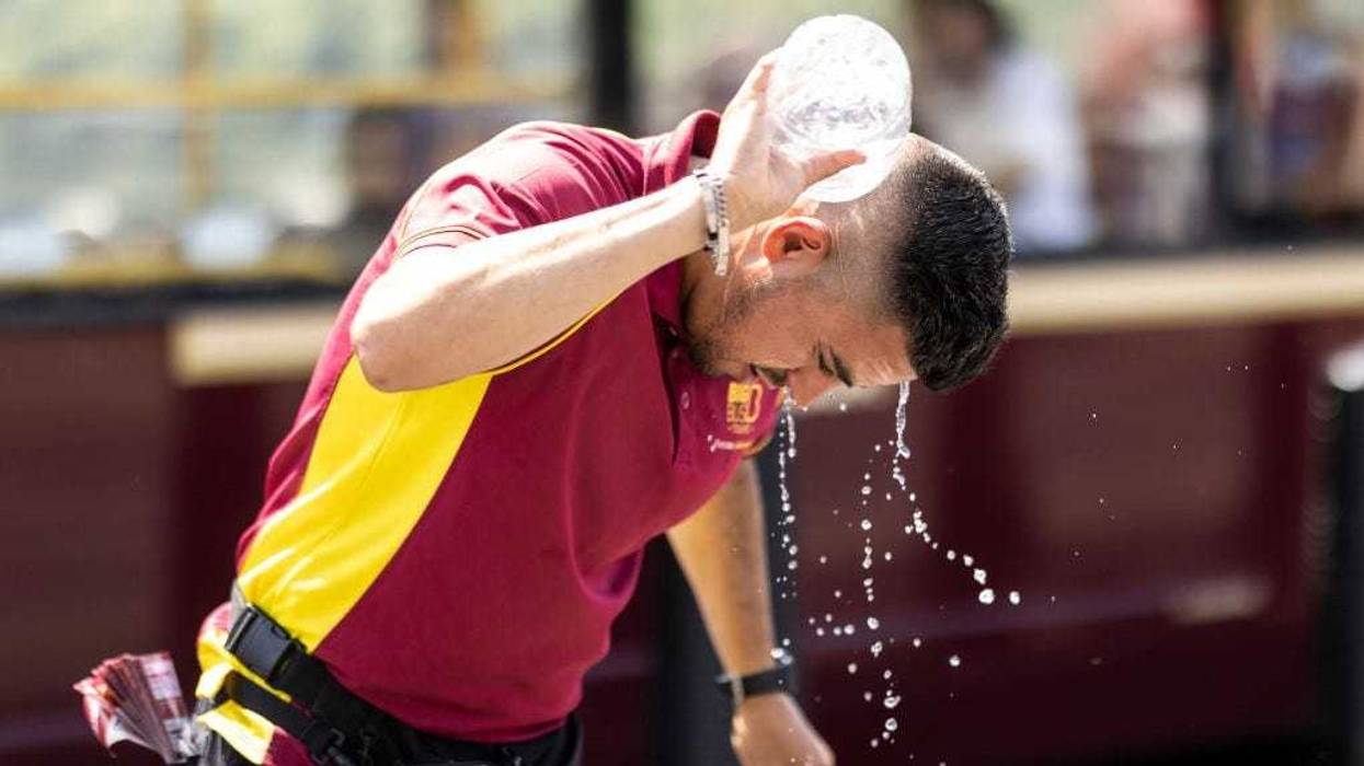 A man pours water over himself on Westminster Bridge on July 19, 2022 in London, United Kingdom.