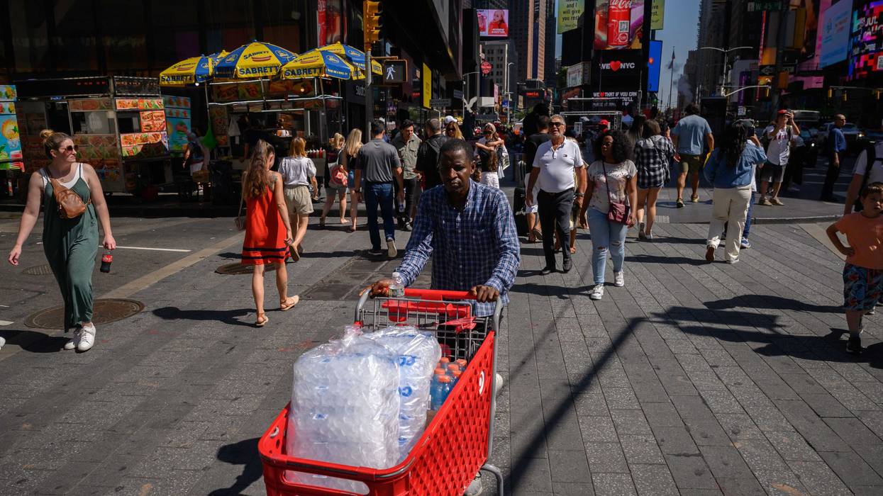 A man pushes a cart filled with ice through Times Square on July 28, 2023