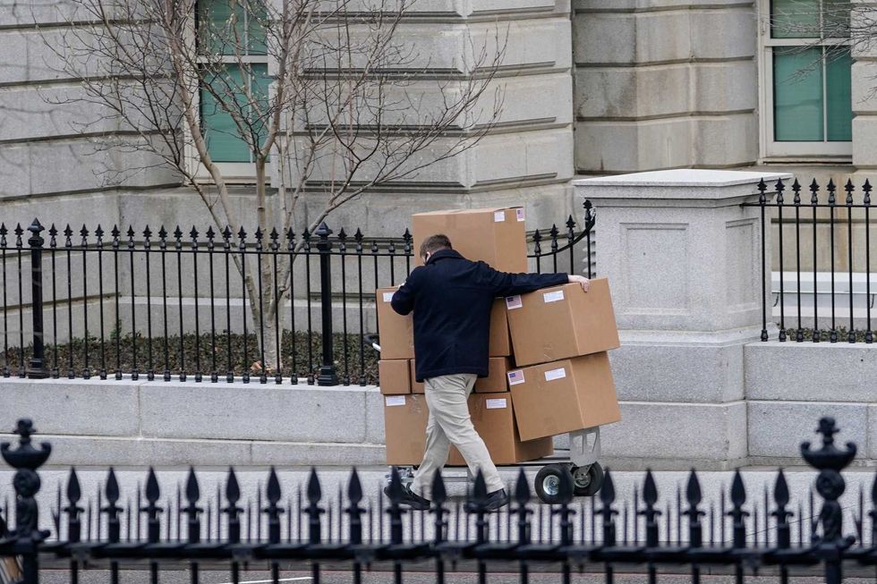 A man pushes a large cart full of boxes along West Executive Avenue between the West Wing of the White House and the Eisenhower Executive Office Building on January 15, 2021 in Washington, DC. According to recent news reports, President Donald Trump is slated to leave Washington the morning of Jan. 20th, hours before President-elect Joe Biden will be sworn-in as president.