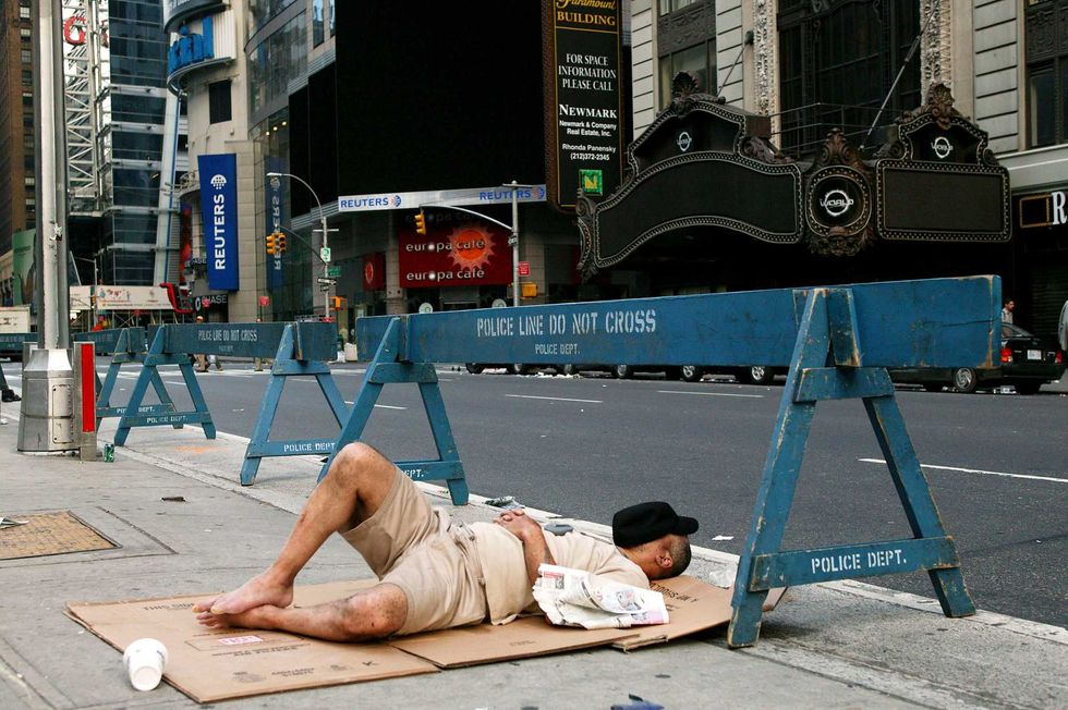 A man sleeps in Times Square on August 15, the second day of the blackout.
