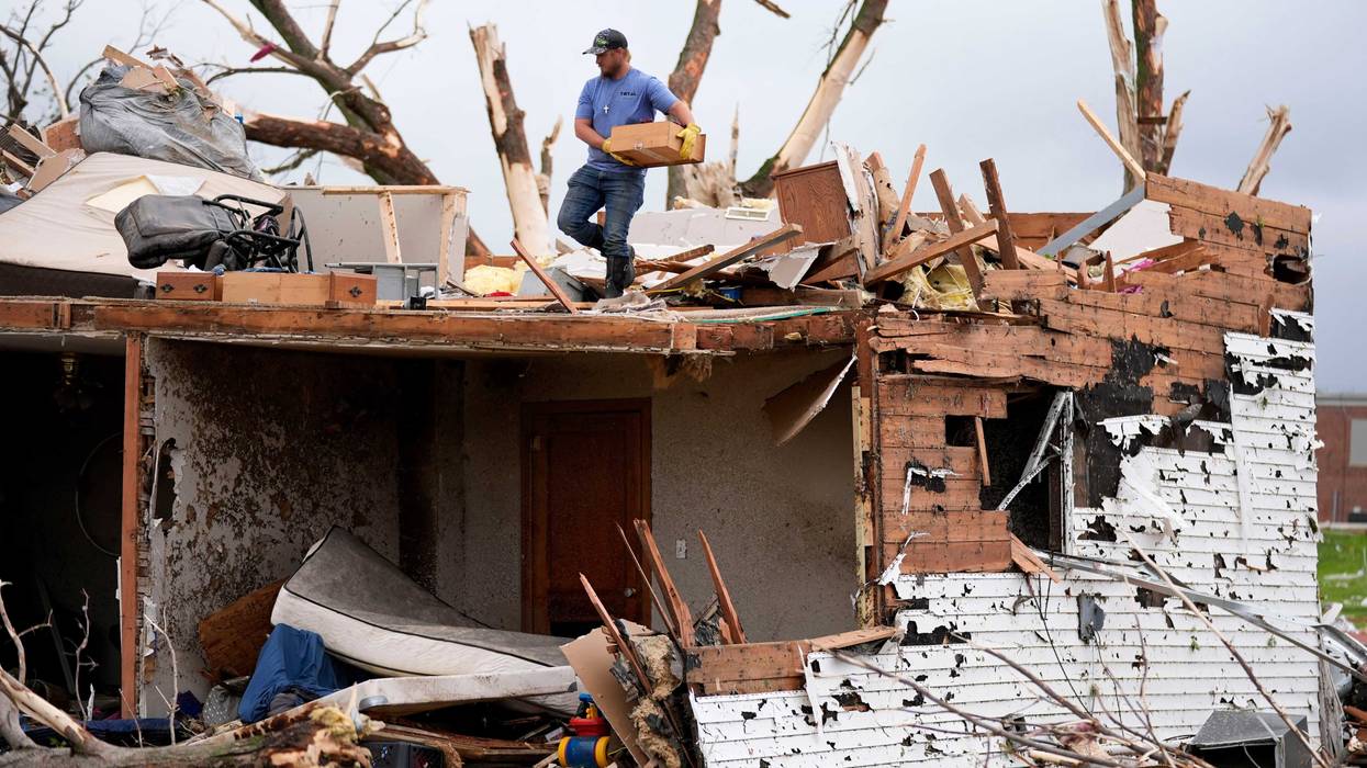A man sorts through the remains of a home damaged by a tornado Tuesday, May 21, 2024, in Greenfield, Iowa.