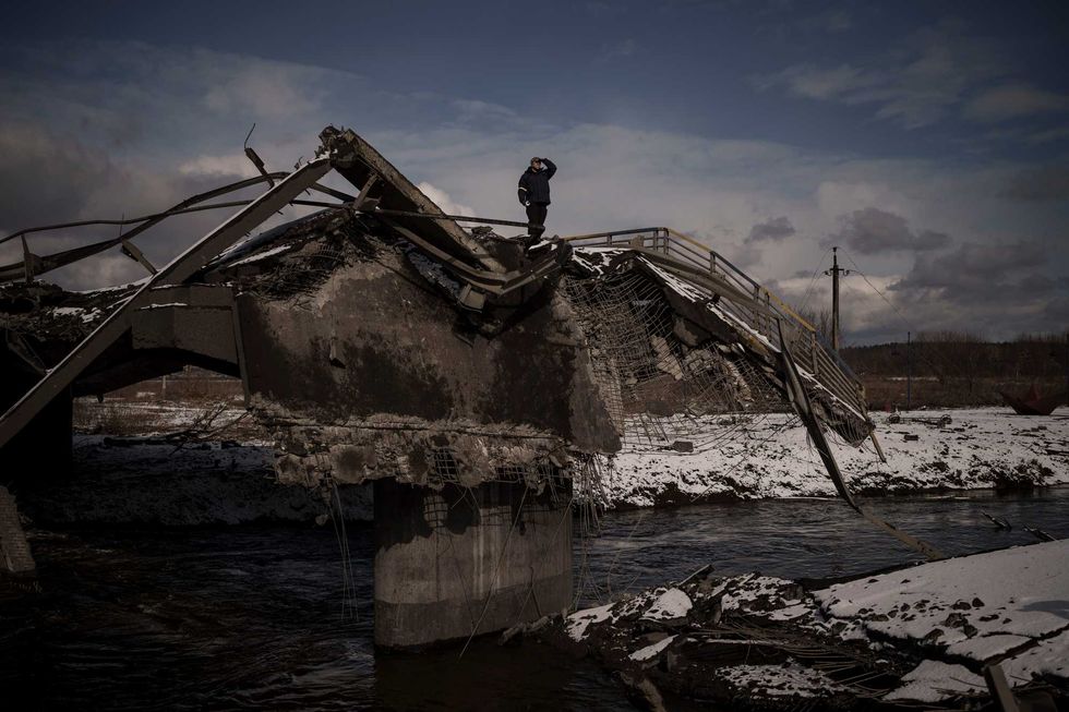 A man stands atop a destroyed bridge in Irpin, on the outskirts of Kyiv, Ukraine, Tuesday, March 8, 2022