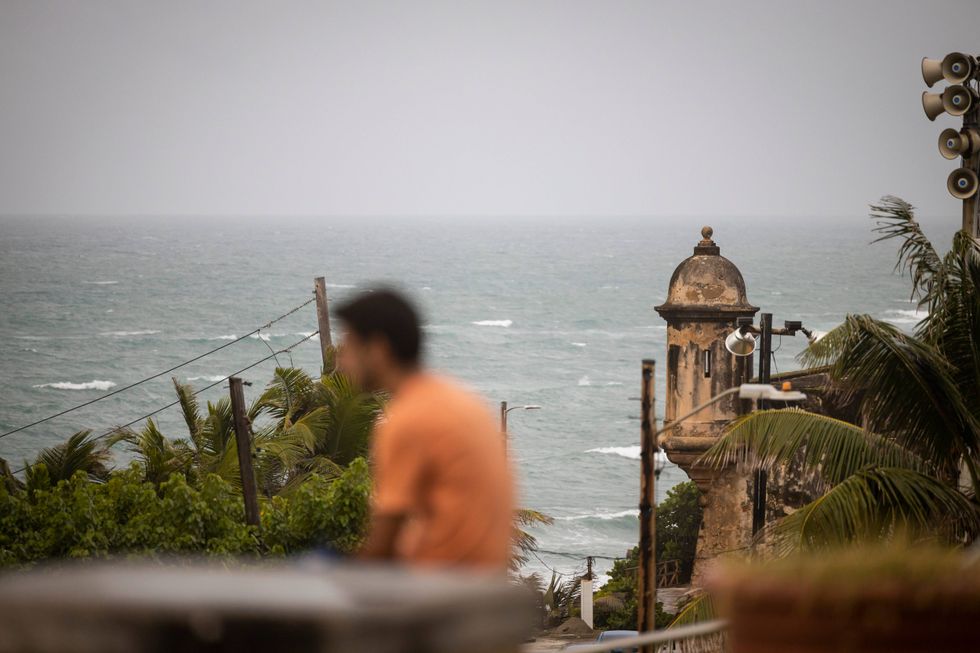 A man stands in front of a beach in San Juan, Puerto Rico, on Saturday, Sept. 17, 2022, a day before the arrival of Hurricane Fiona.