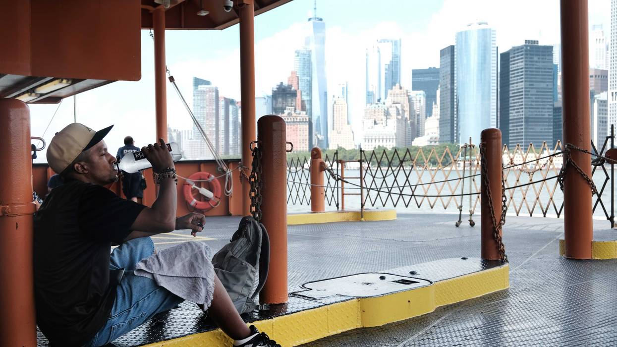 A man takes a drink of water while riding on the Staten Island Ferry on a sweltering afternoon as temperatures reach into the 90s on July 21, 2022 in New York City