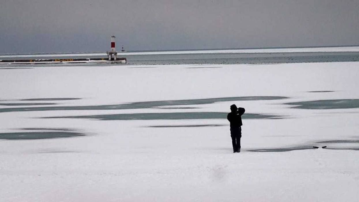 A man takes a picture along the frozen shoreline of Lake Michigan on January 24, 2022 in Chicago, Illinois.