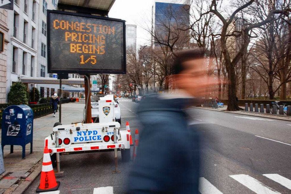 A man walks past a congestion pricing warning sign on Fifth Avenue as congestion pricing takes effect in New York City on Jan. 5, 2024.