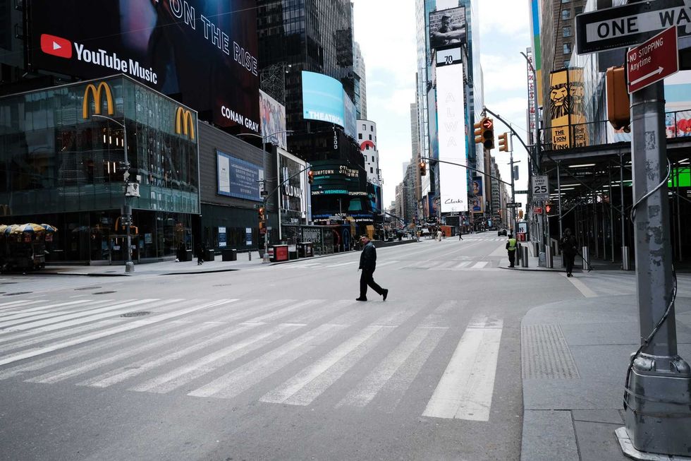 A man walks through a mostly empty Times Square on March 22, 2020, as the COVID-19 pandemic was beginning to grip the city. A new survey says the five boroughs have come a long way since then