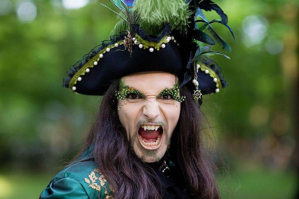 A man with fake vampire teeth wearing a costume attends the traditional park picnic on the first day of the annual Wave-Gotik Treffen, or Wave and Goth Festival, on May 17, 2013 in Leipzig, Germany.
