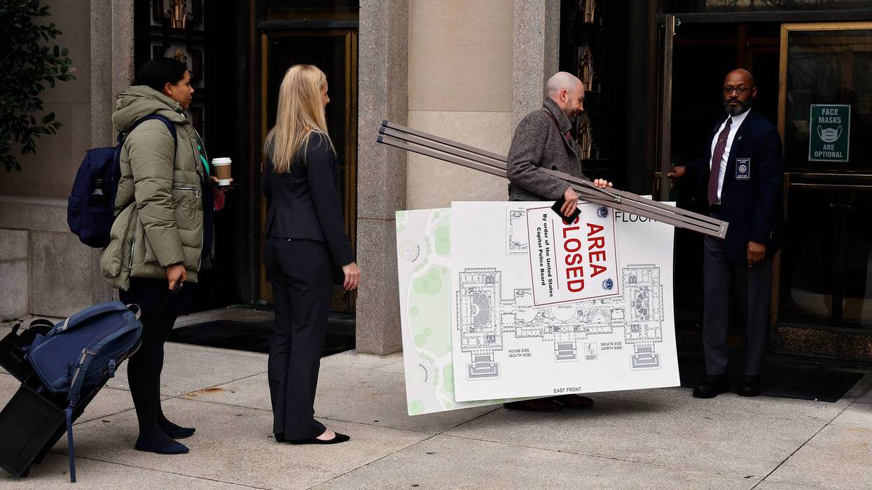 A map of the U.S. Capitol and an example of a sign used by police on Jan. 6, 2021, are carried into the U.S. District Court building on Jan. 12, 2023, in Washington, D.C. Opening arguments have begun in the trial of members of the Proud Boys accused of seditious conspiracy for their role in the attack on the U.S. Capitol.
