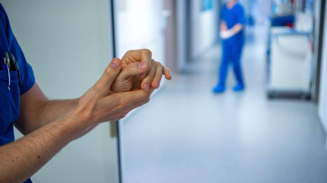 A medical staff wearing a protective mask and clothing cleans hands at the intensive care unit at the St. Josef Hospital on April 1, 2020 in Bochum, Germany.