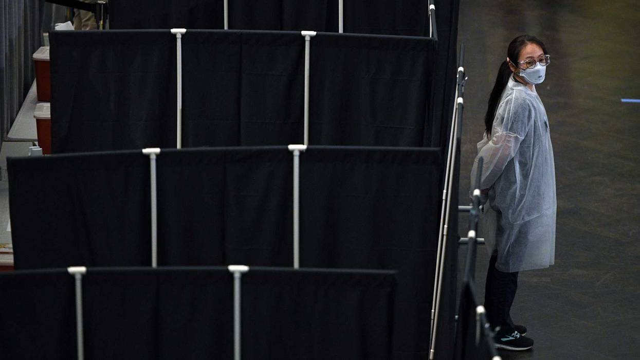 A medical worker stands next to a screened of area for people receiving vaccination shots at the newly opened COVID-19 vaccination site inside the American Museum of Natural History, New York, NY, April 23, 2021