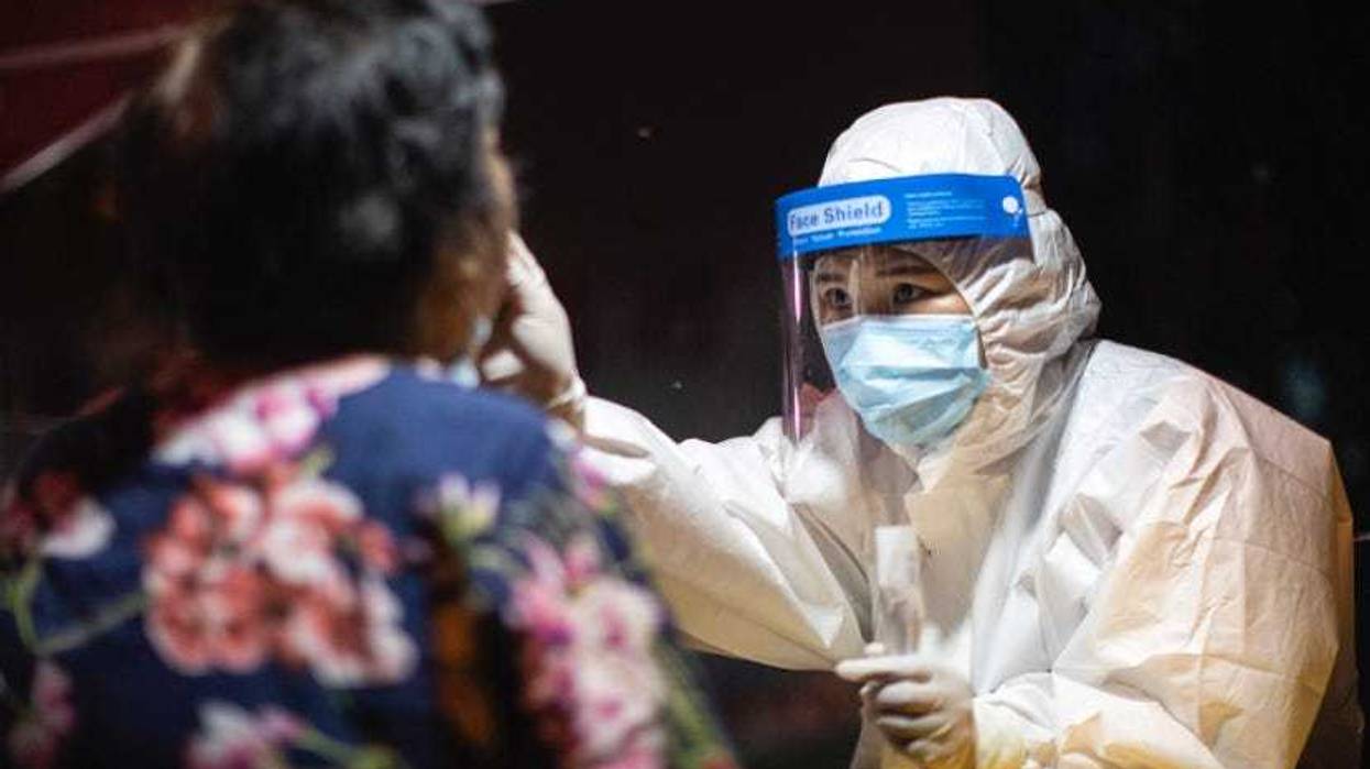 A medical worker takes samples during a mass Covid-19 test in a residential block in Wuhan, China.