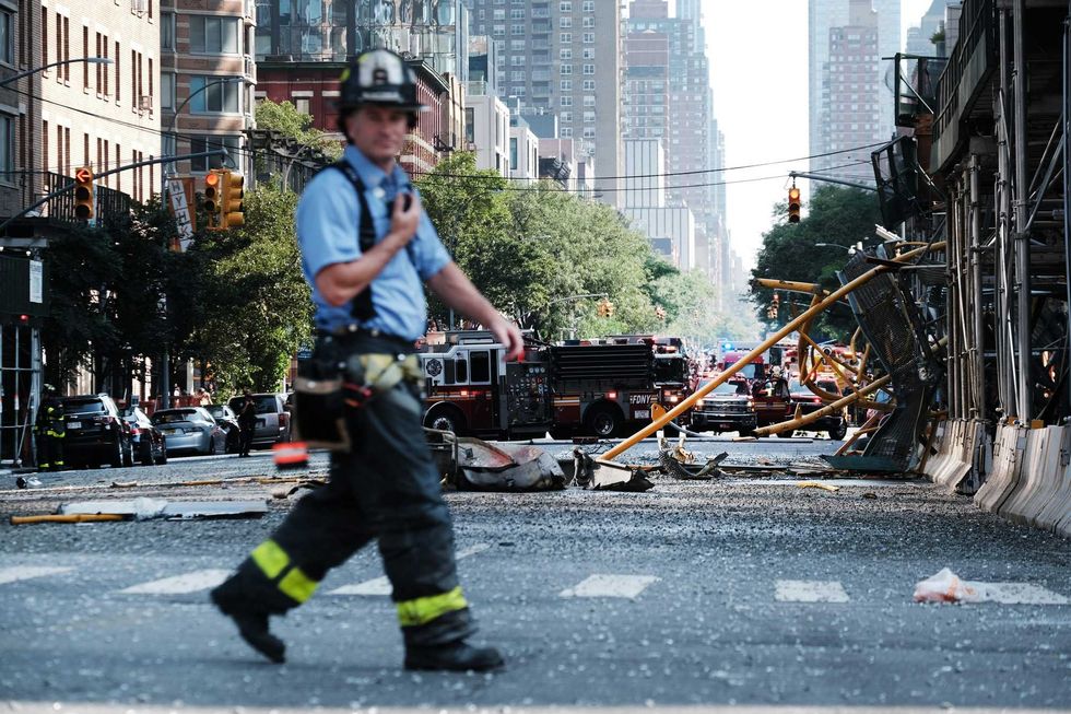 A member of the FDNY walks past the collapsed crane boom