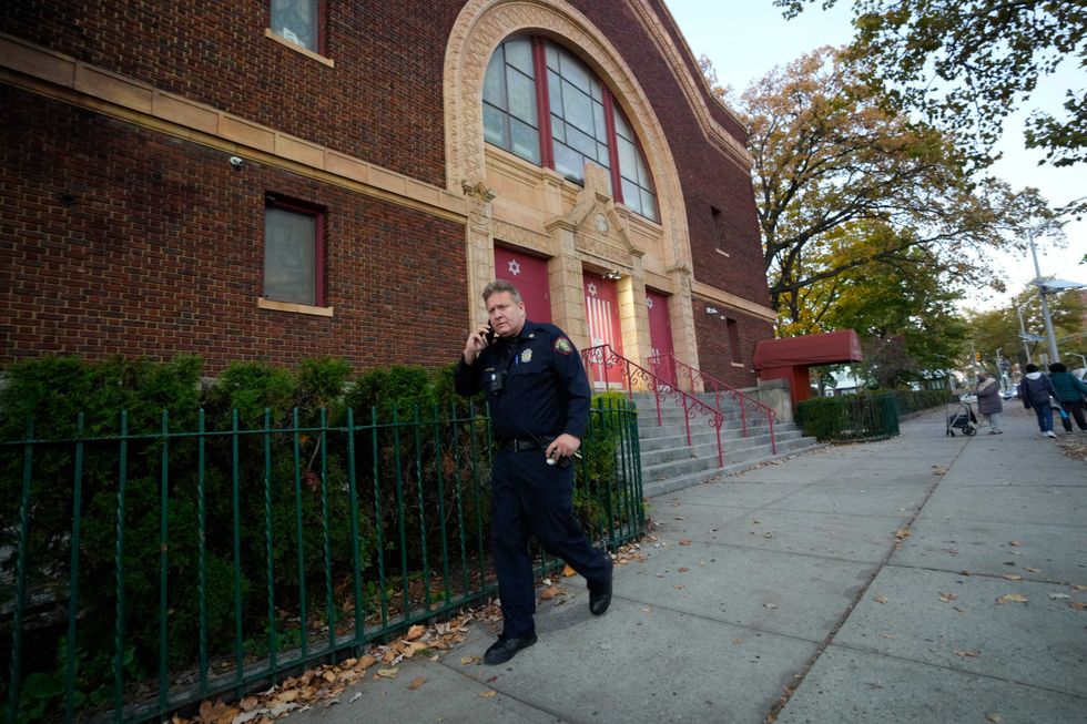 A member of the Jersey City Police Department is shown as he walks in front of Temple Beth El on Thursday, November 3, 2022.