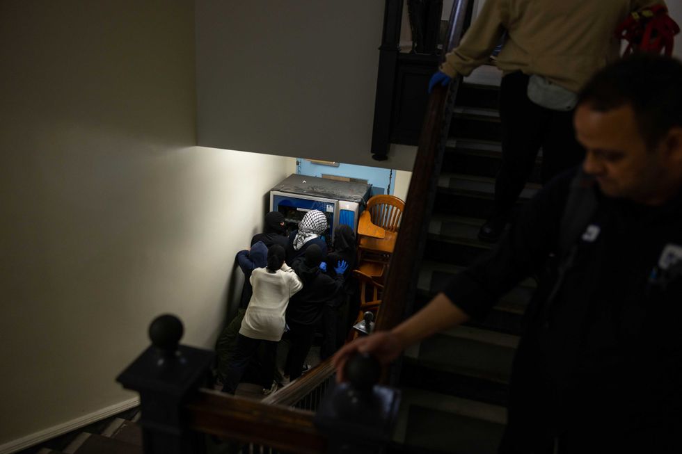 A member of the maintenance team is escorted out, but is met with a barricaded door on Tuesday, April 30, 2024