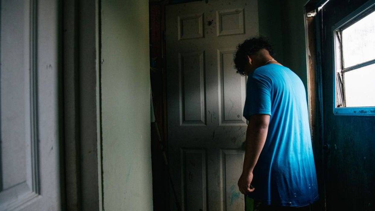 A member of the Maldonado family walk through the house after it flooded during Hurricane Ida.