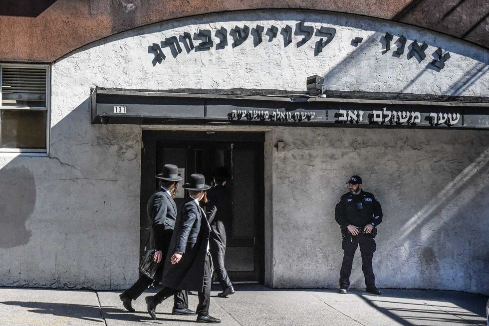 A member of the NYPD patrols in front of a synagogue on Oct. 13, 2023 in Williamsburg