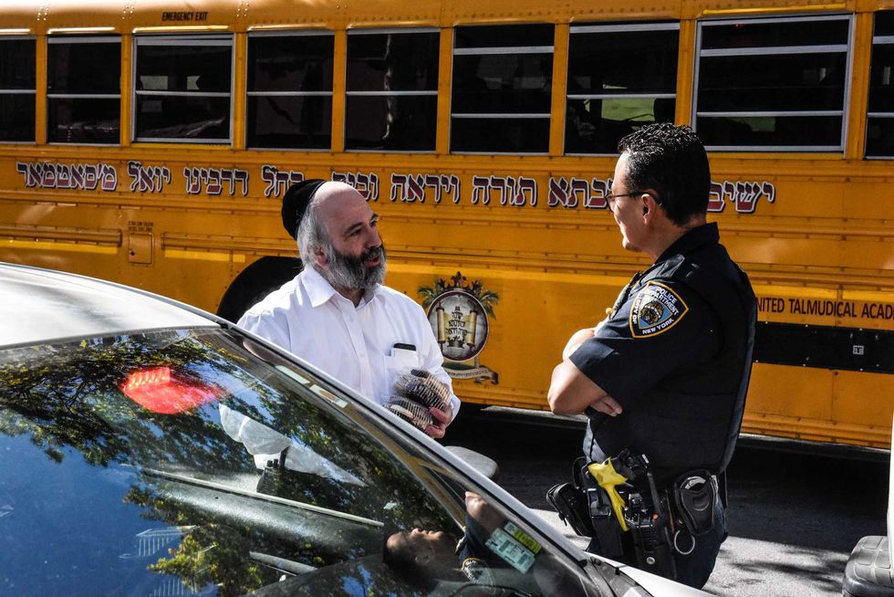 A member of the NYPD speaks with a resident on Oct. 13, 2023 in Williamsburg