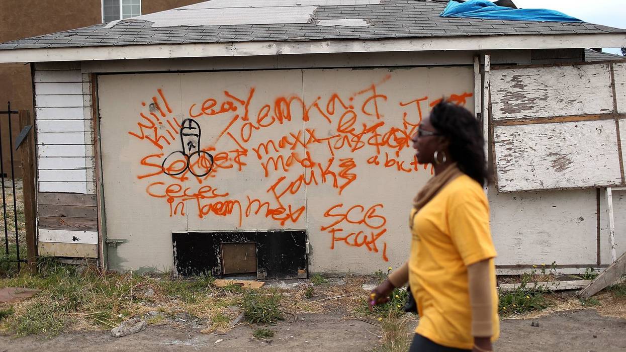 A member of the Richmond, California chapter of the Alliance of Californians for Community Empowerment (ACCE) walks by an abandoned garage during a bus tour of foreclosed and blighted properties on July 13, 2012 in Richmond, California.