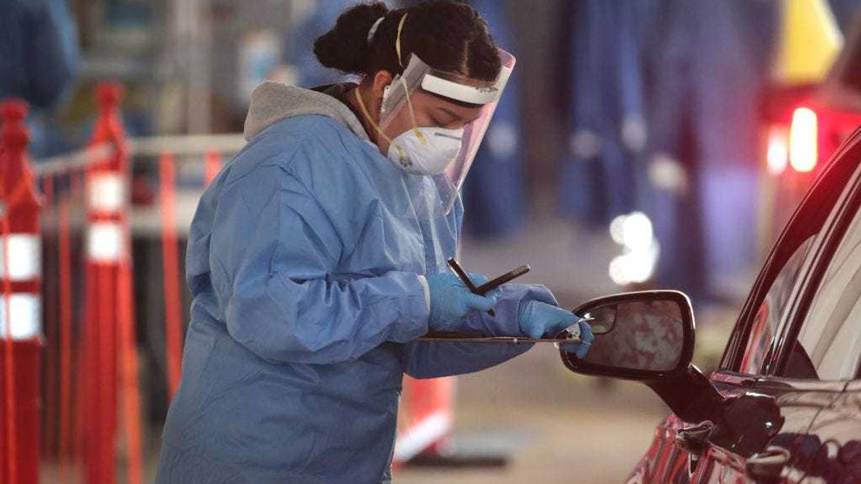 A member of the Wisconsin National Guard helps to test residents for COVID-19 at a drive-up test center at Miller Park on November 17, 2020 in Milwaukee, Wisconsin.