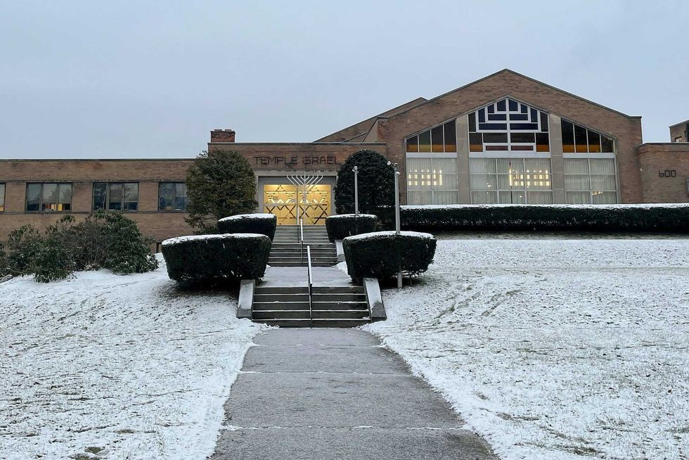 A menorah stands outside the entrance to Temple Israel, Thursday, Dec. 7, 2023, in Albany, N.Y. A 28-year-old suspect was in police custody for allegedly firing two rounds from a shotgun outside the Jewish temple on Friday, just hours before the start of Hanukkah. Officials said no one was injured and police they did not know the man