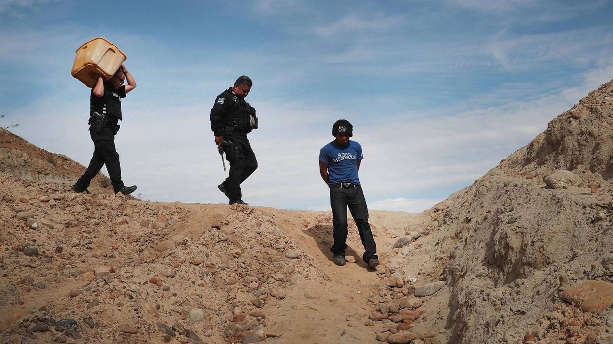 A migrant is taken into custody by Mexican police