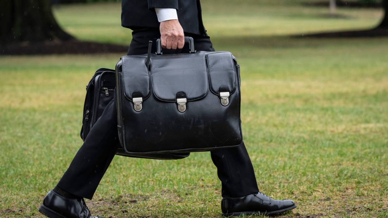 A military aide carries the "nuclear football," which contains launch codes for nuclear weapons, while walking to Marine One on the South Lawn of the White House on Oct. 3, 2022, in Washington, D.C.